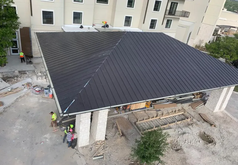 Metal roofing installation team working on a commercial building in Murillo